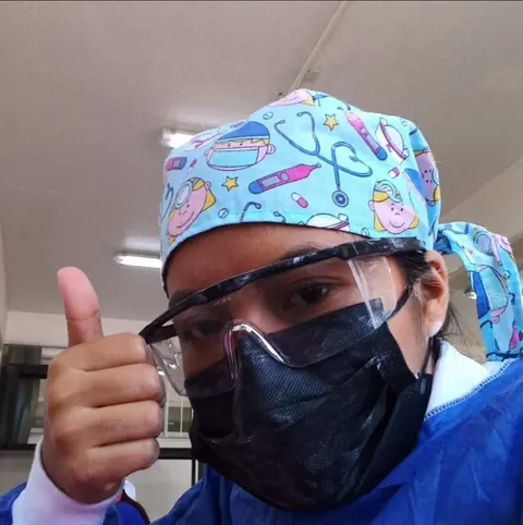 Dariana con lentes de protección y gorro estampado haciendo un pulgar arriba